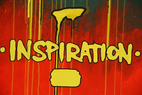 A person surrounded by colorful light bulbs, symbolizing creativity and inspiration for mundane tasks.